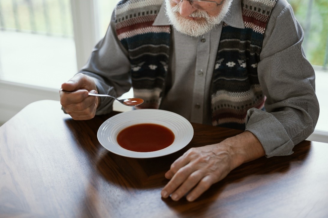 Idoso tomando sopa